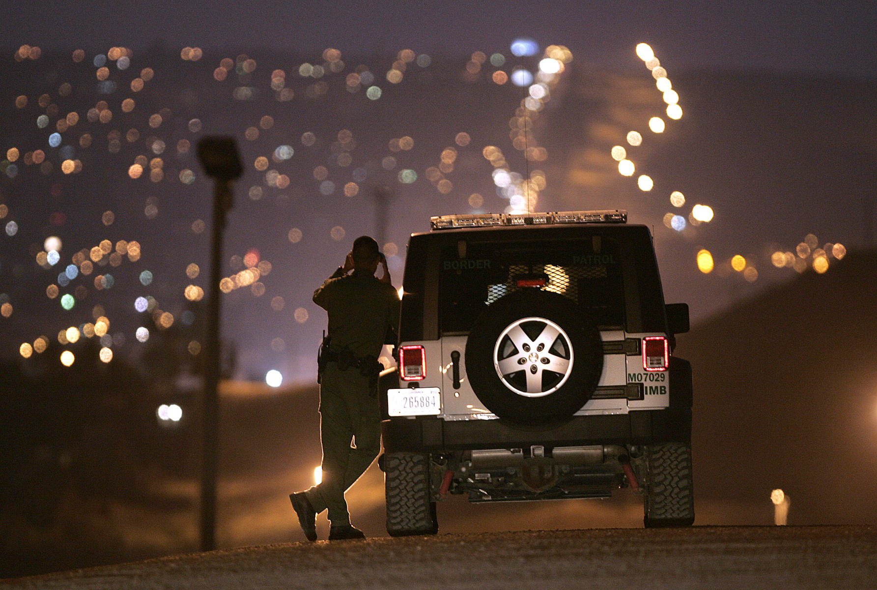 A US Customs and Border Patrol Agent watching the US-Mexico Border. 