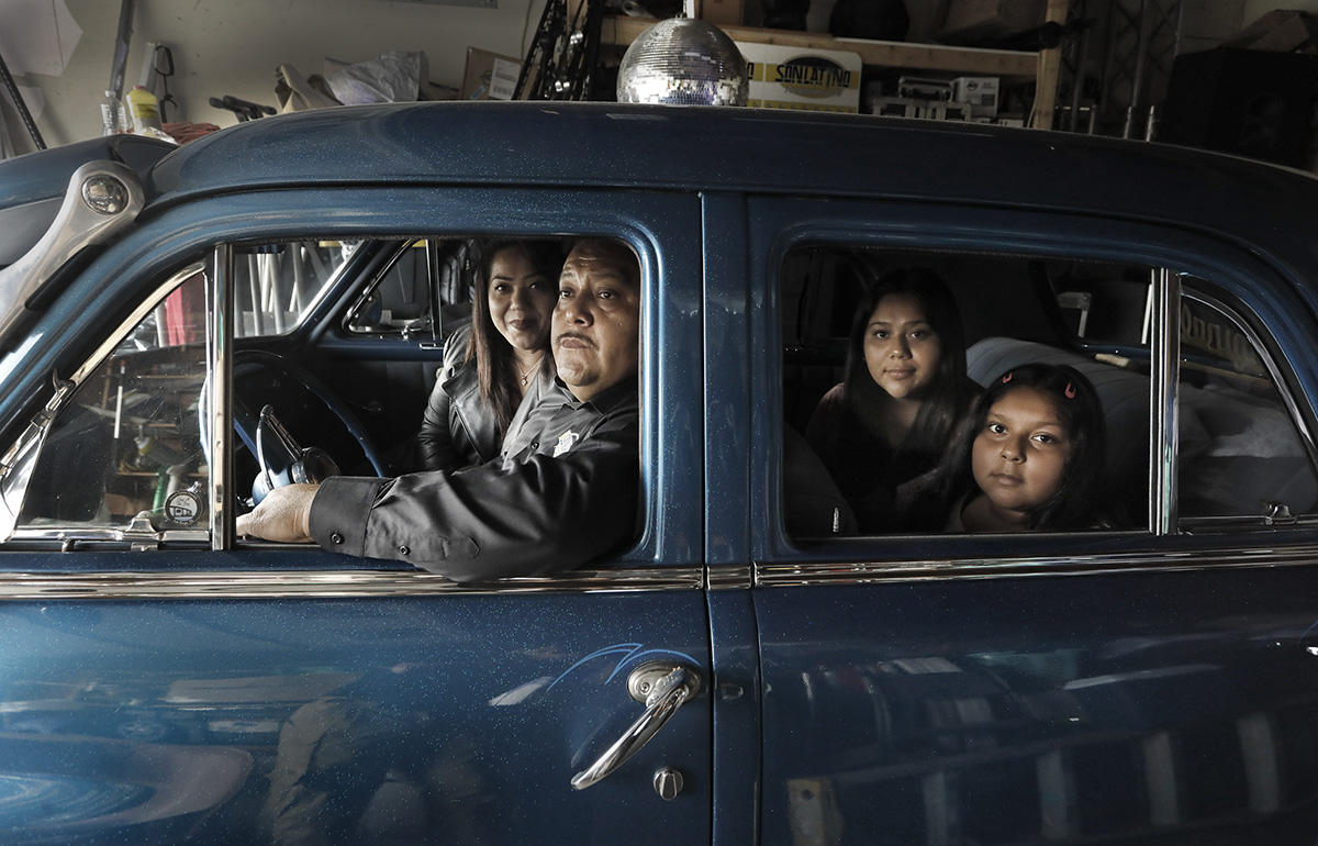 Juan Lira and family sit in the the family's vintage 1950 Plymouth in June.  His business as a DJ for large events, weddings and birthdays won't start up anytime soon, it was decimated starting in the Spring of 2020.  