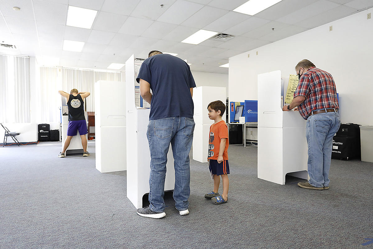 Little Nicky Ruiz Jr. watched his father Nick Ruiz, Sr. cast his vote on election day where turnouts set records. 